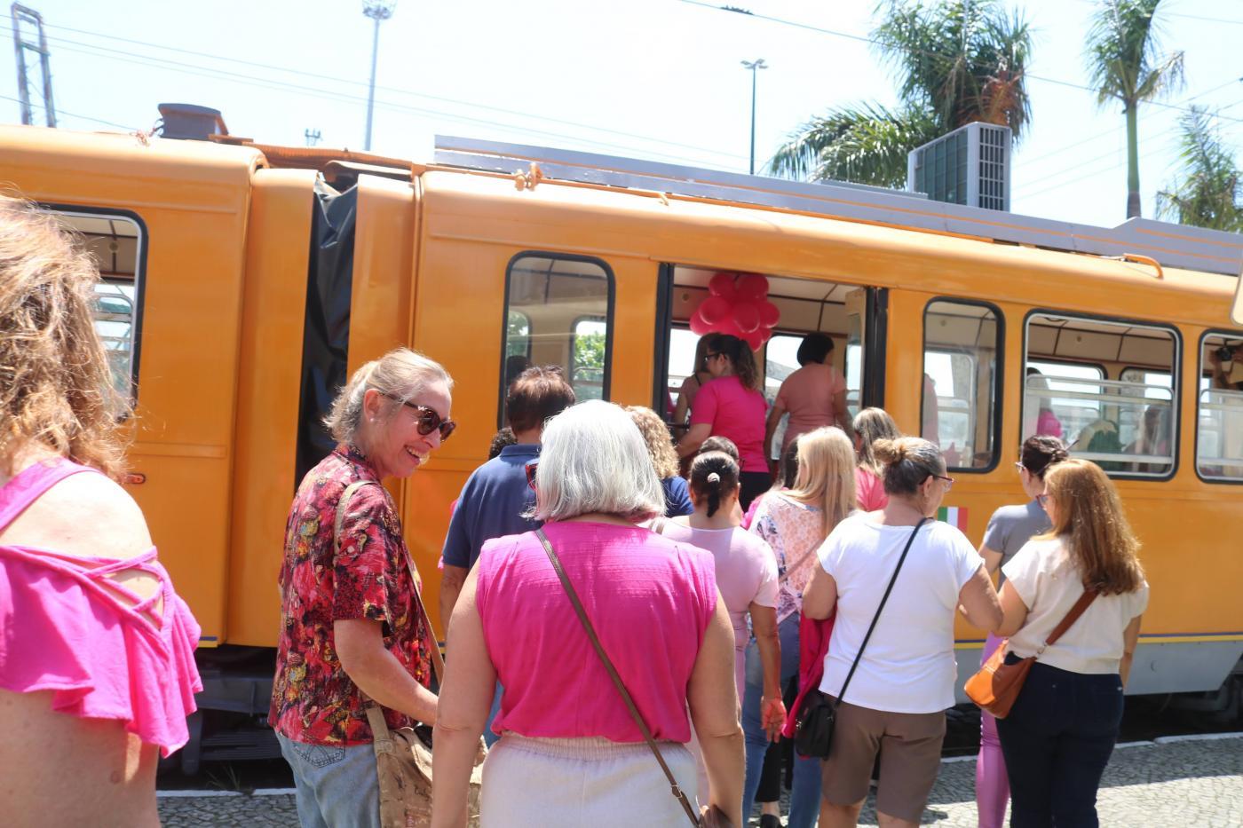 mulheres de rosa entrando no bonde #paratodosverem