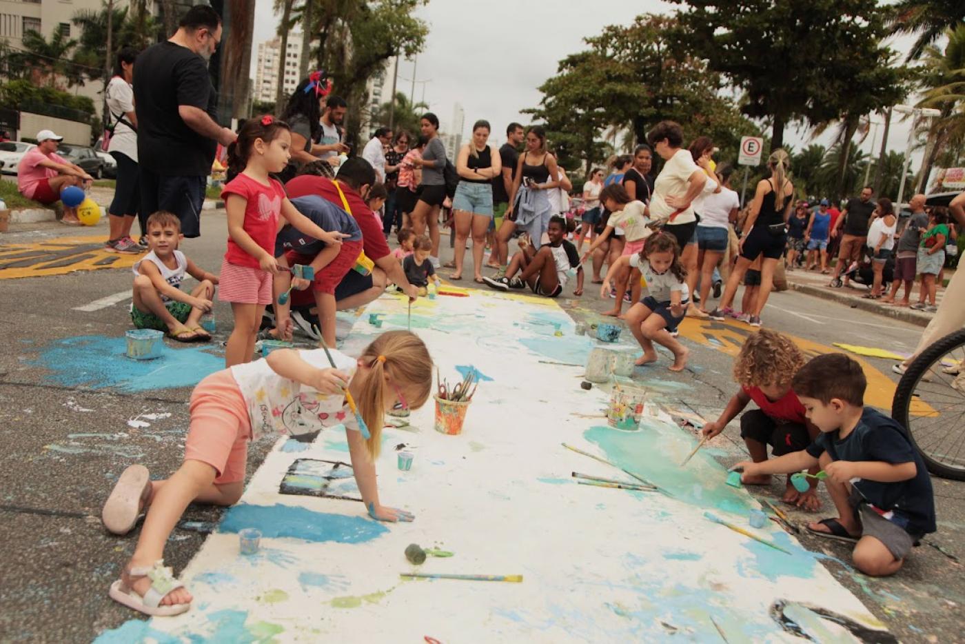 crianças brincam de pintura na avenida da orla #paratodosverem