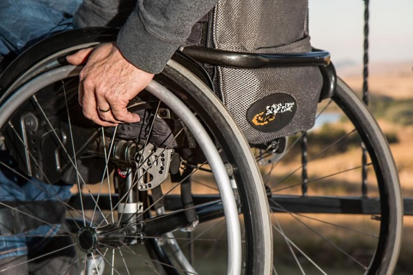 Mão segura cadeira de rodas em destaque. #pratodosverem