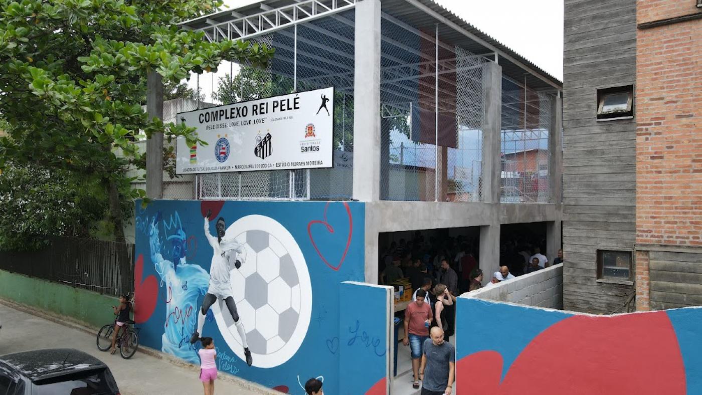 fachada do equipamento com grafite de pelé dando o soco no ar e uma grande bola de futebol ao fundo. #paratodosverem 