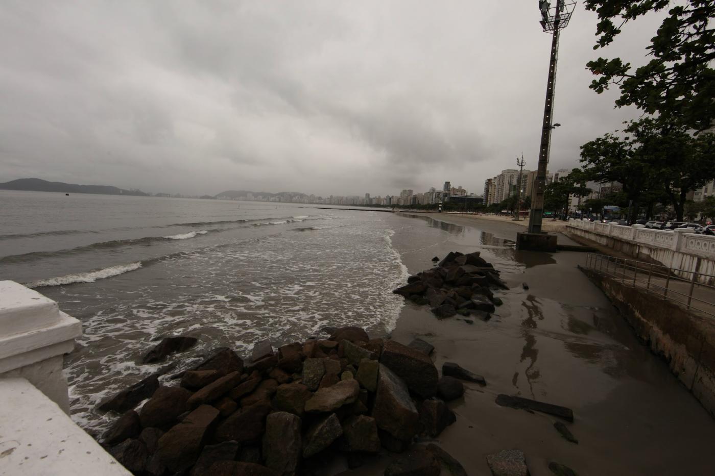 a ponta da praia em tom escuro, prenúncio de chuva. #paratodosverem 