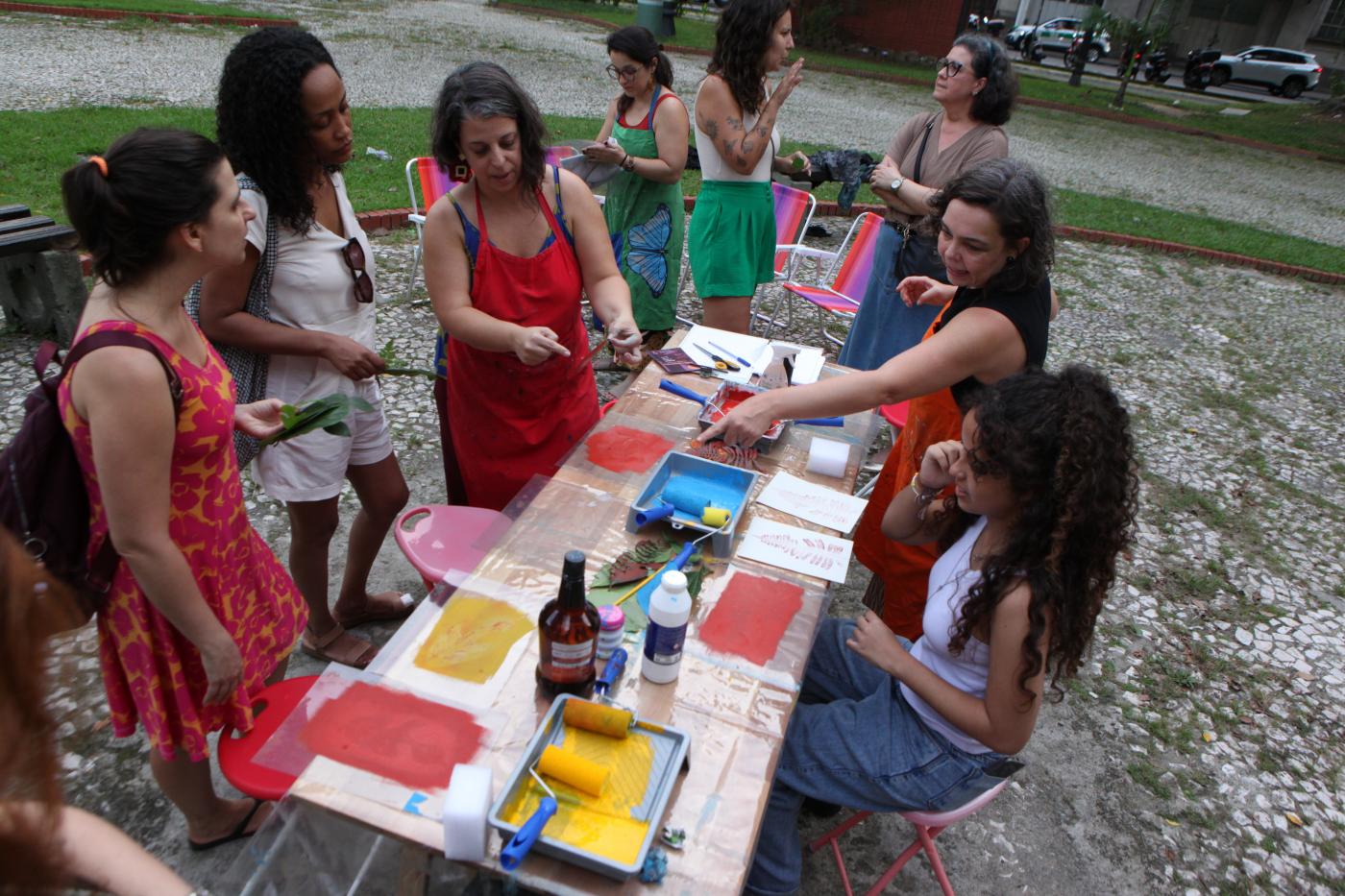 pessoas em volta de mesa com as obras #paratodosverem