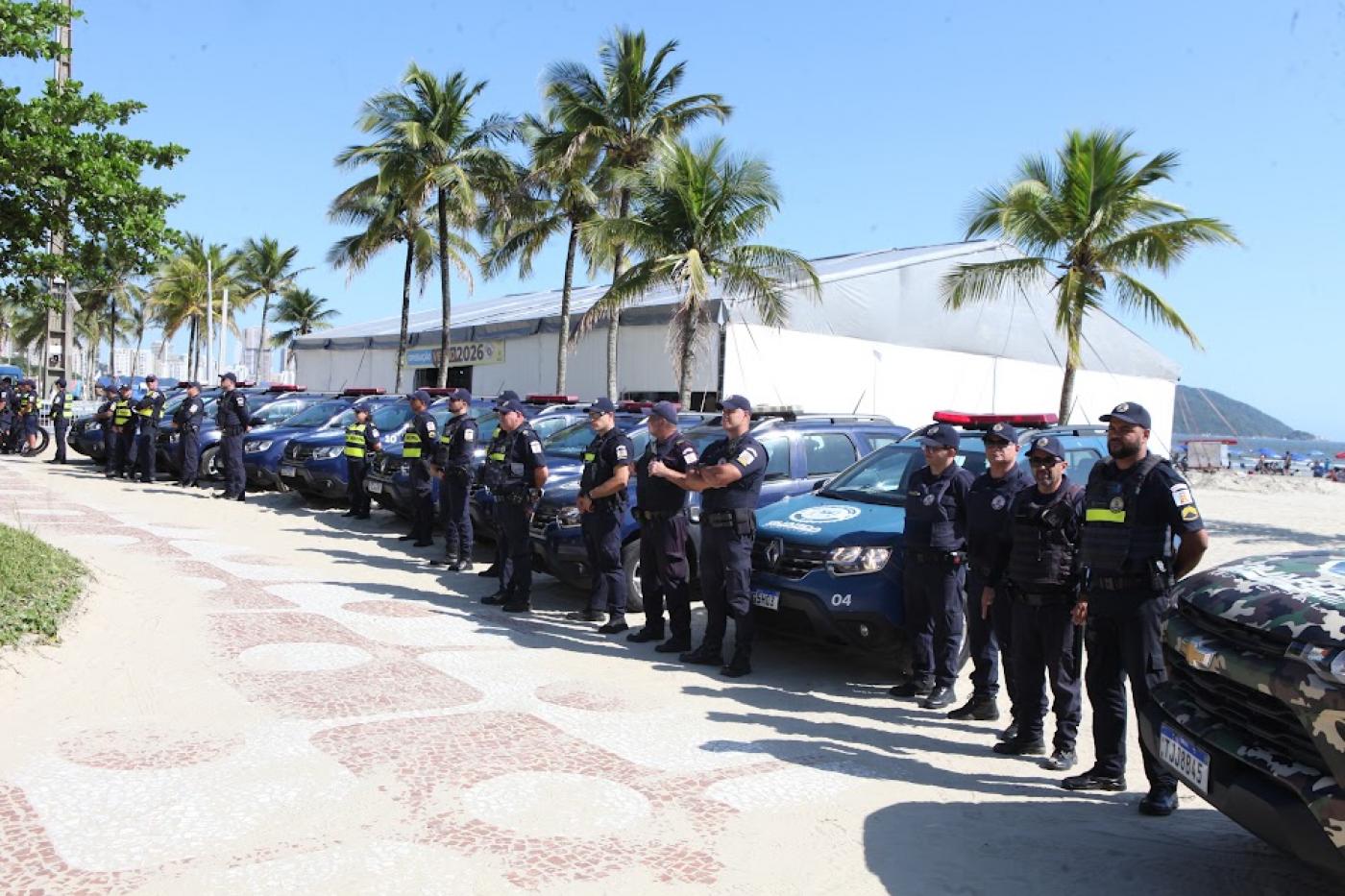 guardas municipais diante de viaturas na orla. #paratodosverem