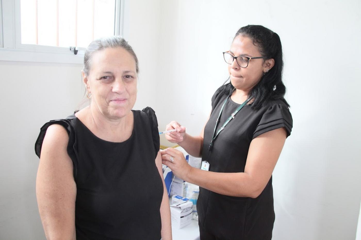 mulher tomando vacina no braço #paratodosverem 