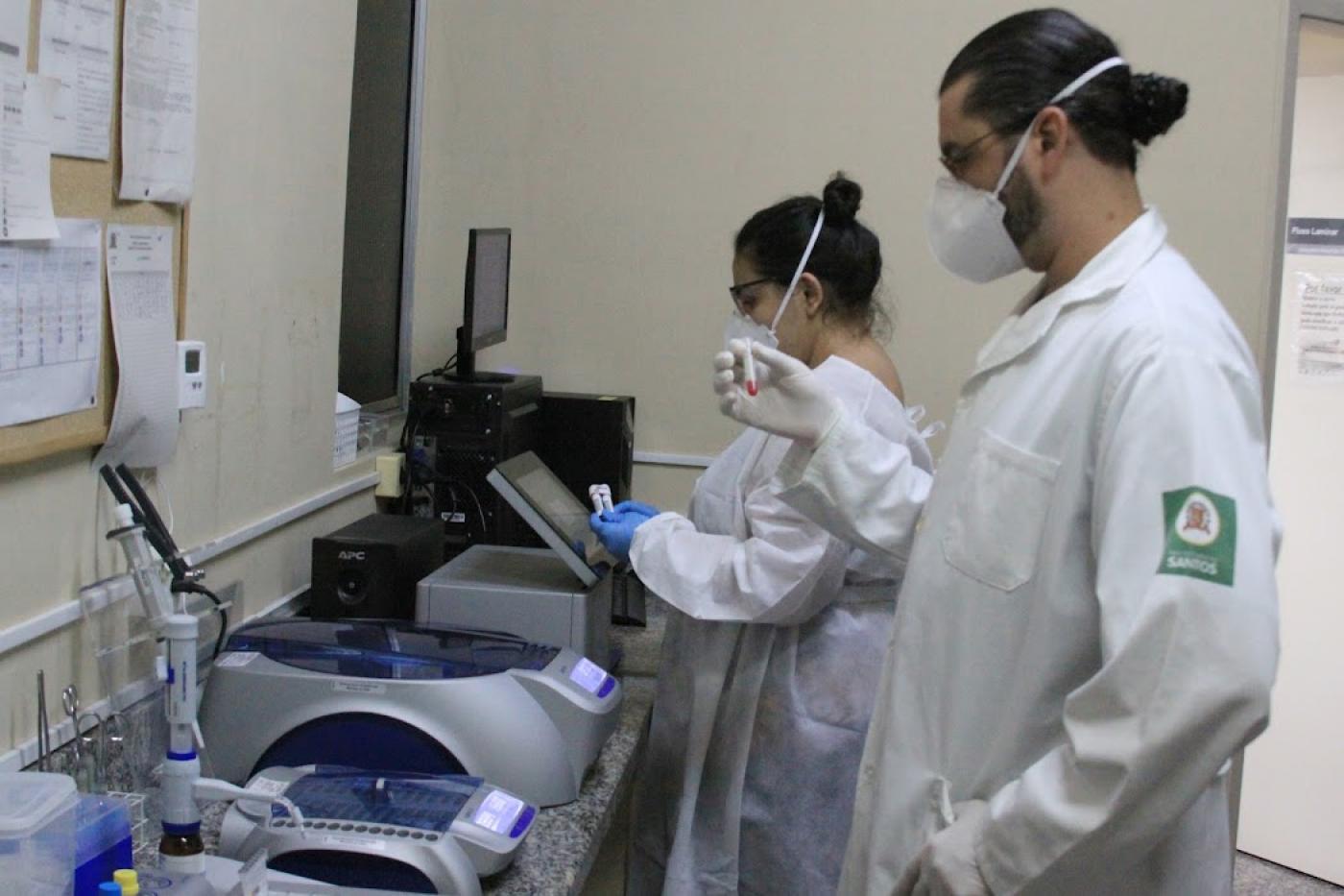 dois profissionais manuseiam aparelhos do laboratório #paratodosverem