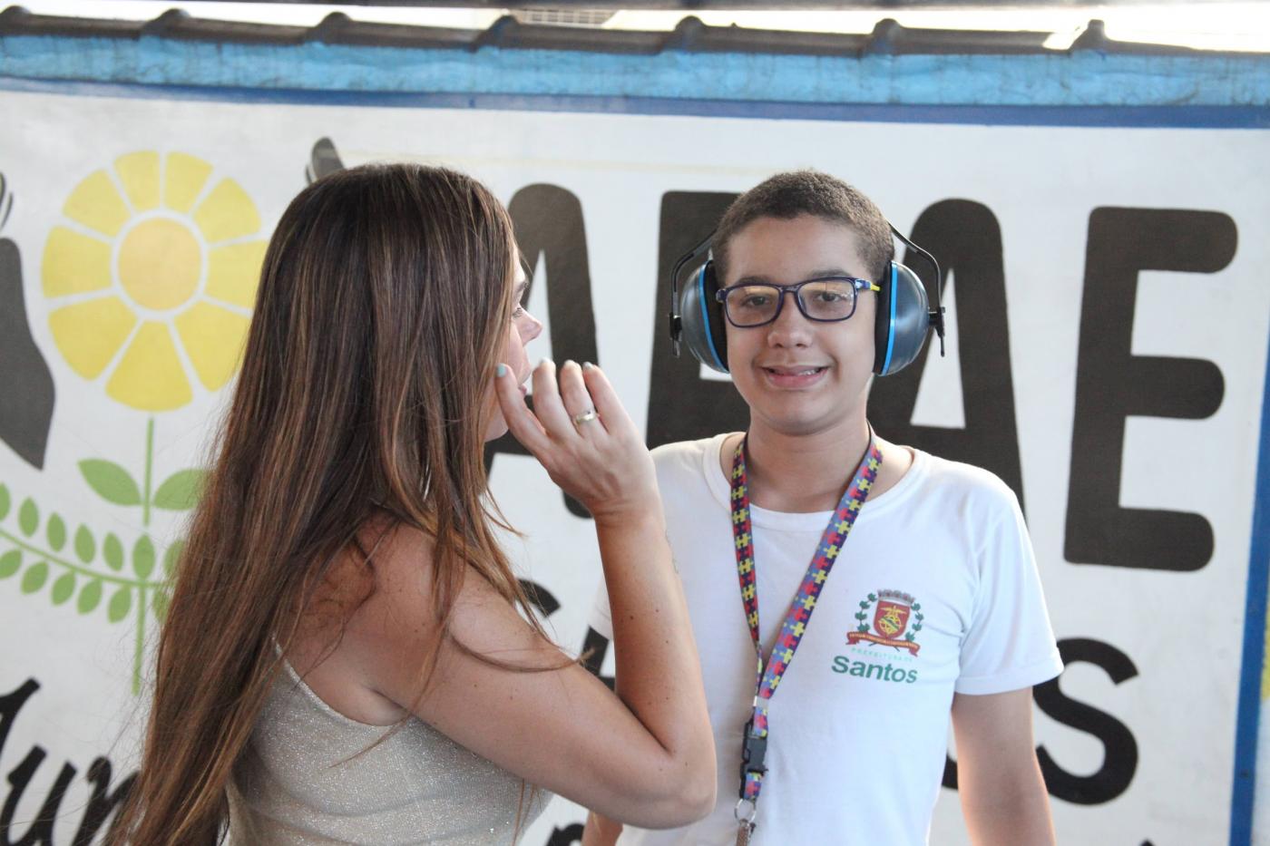 menino sorri usando abafador. #paratodosverem 