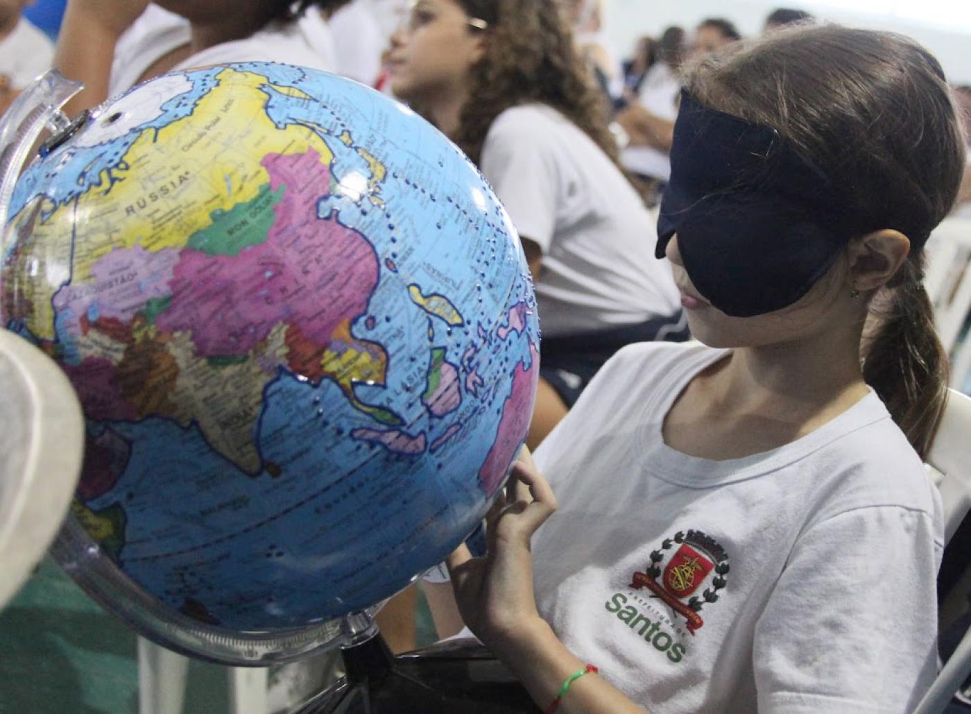 criança com venda encosta em globo #paratodosverem 