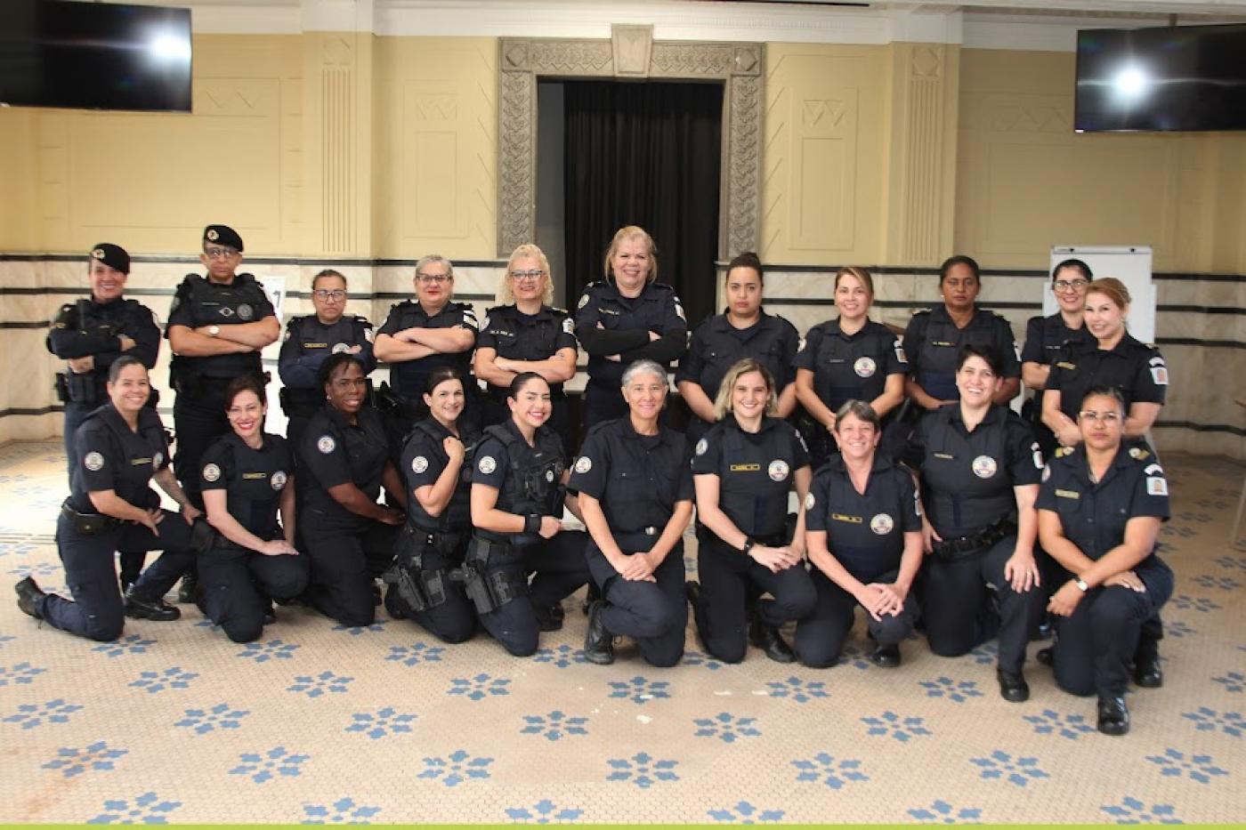 mulheres da guarda posam para foto. São duas fileiras de agentes com 10 delas agachadas jà frente e 11 em pé atrás. #paratodosverem 