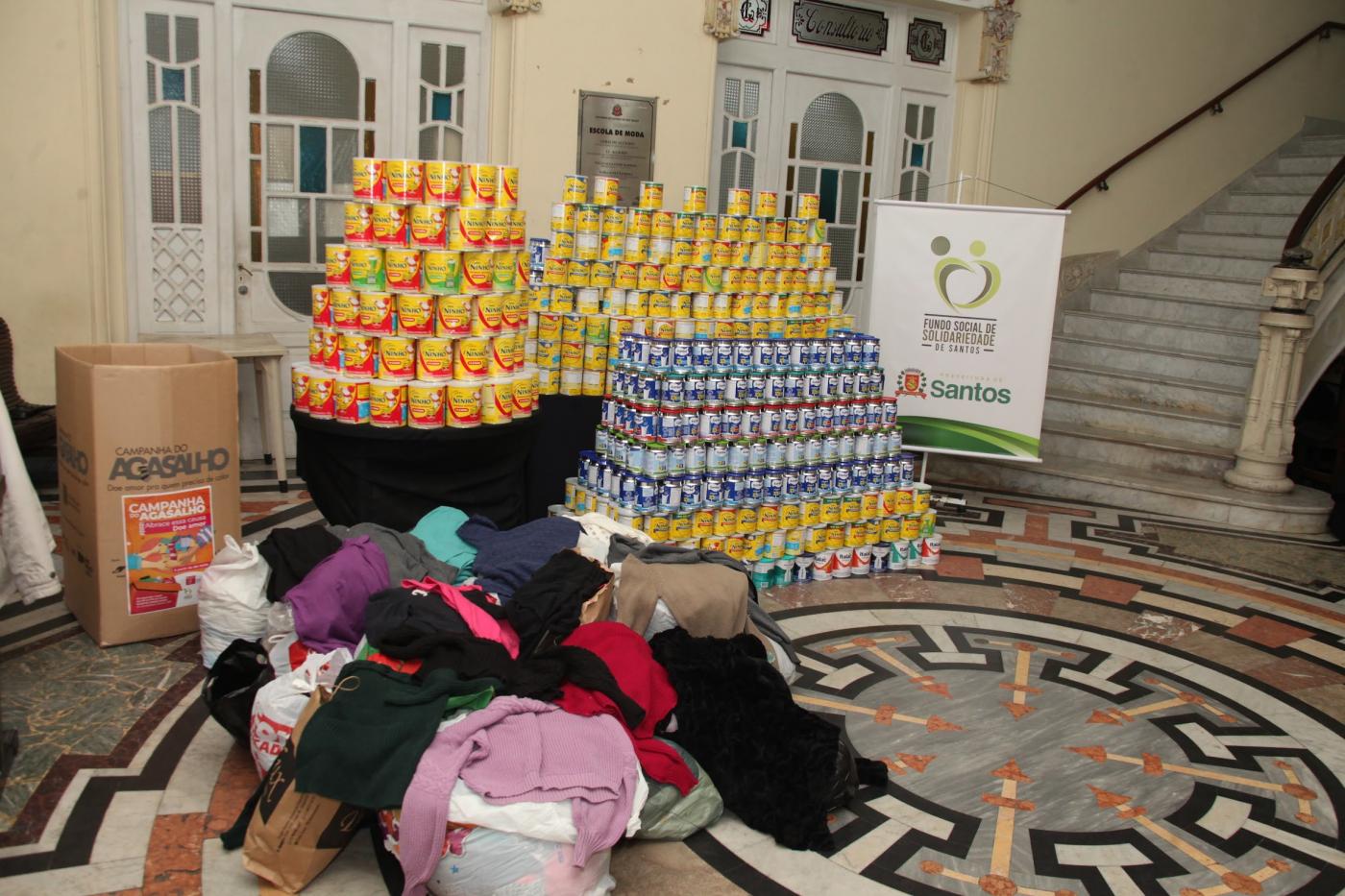 latas de leite expostas no saguão do fundo de solidariedade. #paratodosverem