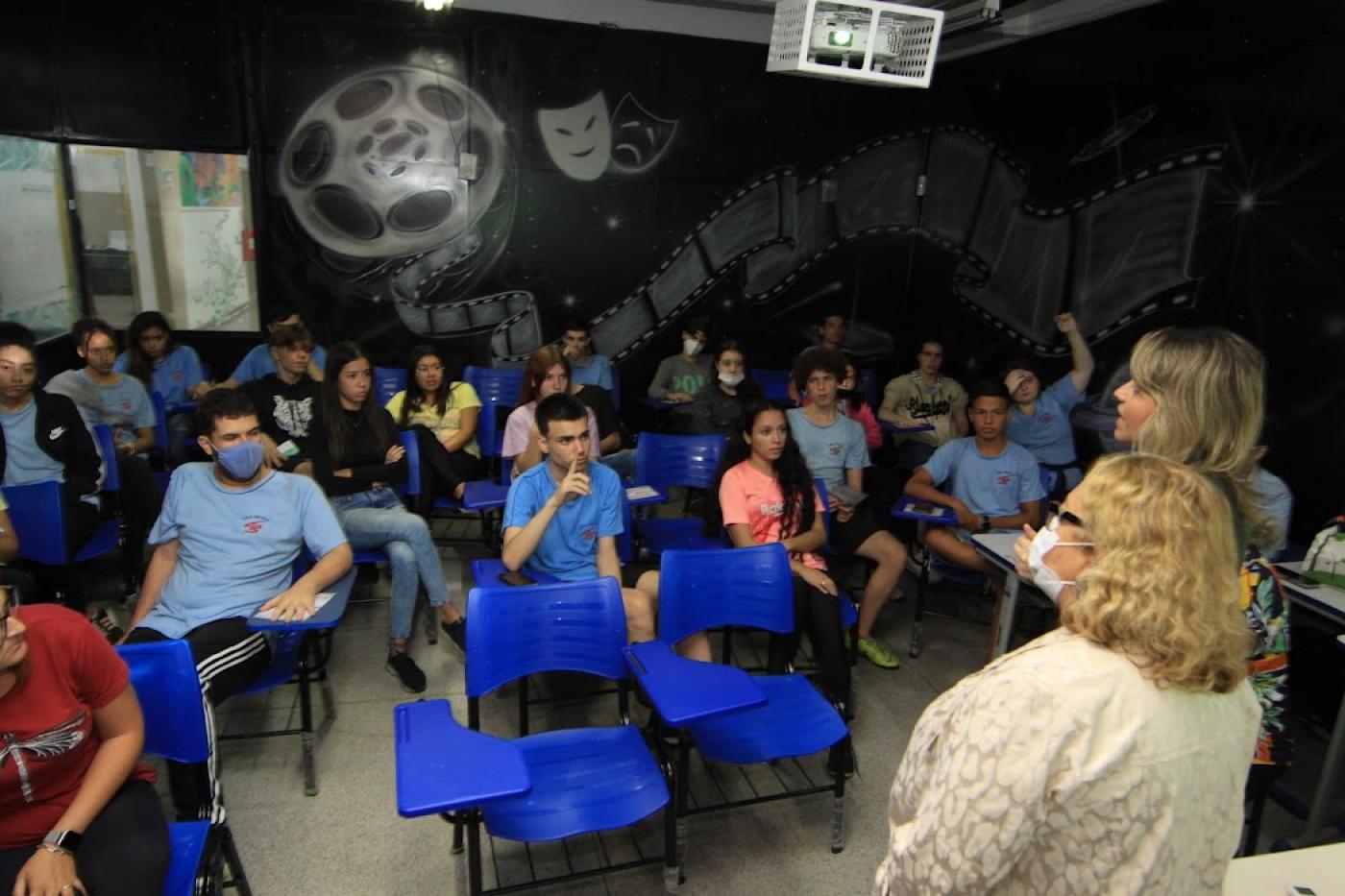alunos observam palestrantes em sala #paratodosverem
