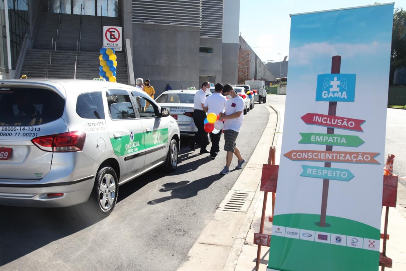 carros estão em fila e são decorados com bexigas coloridas. #paratodosverem