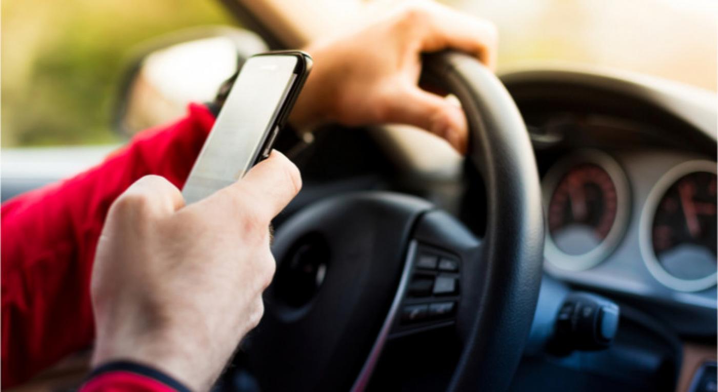 pessoa usando celular ao volante #paratodosverem