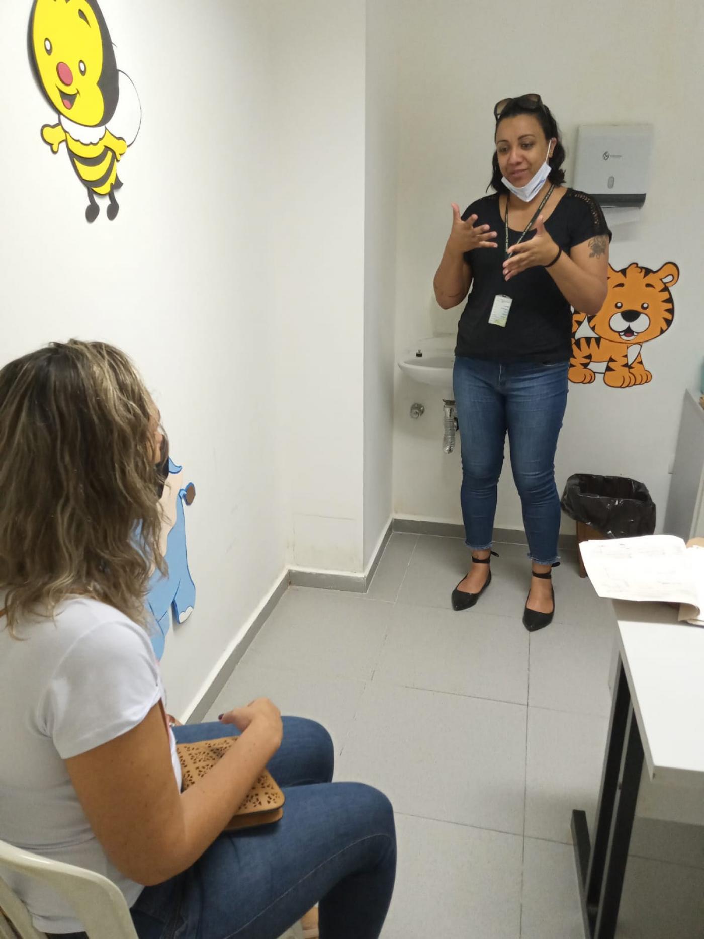Mulher fala em libras com paciente #paratodosverem