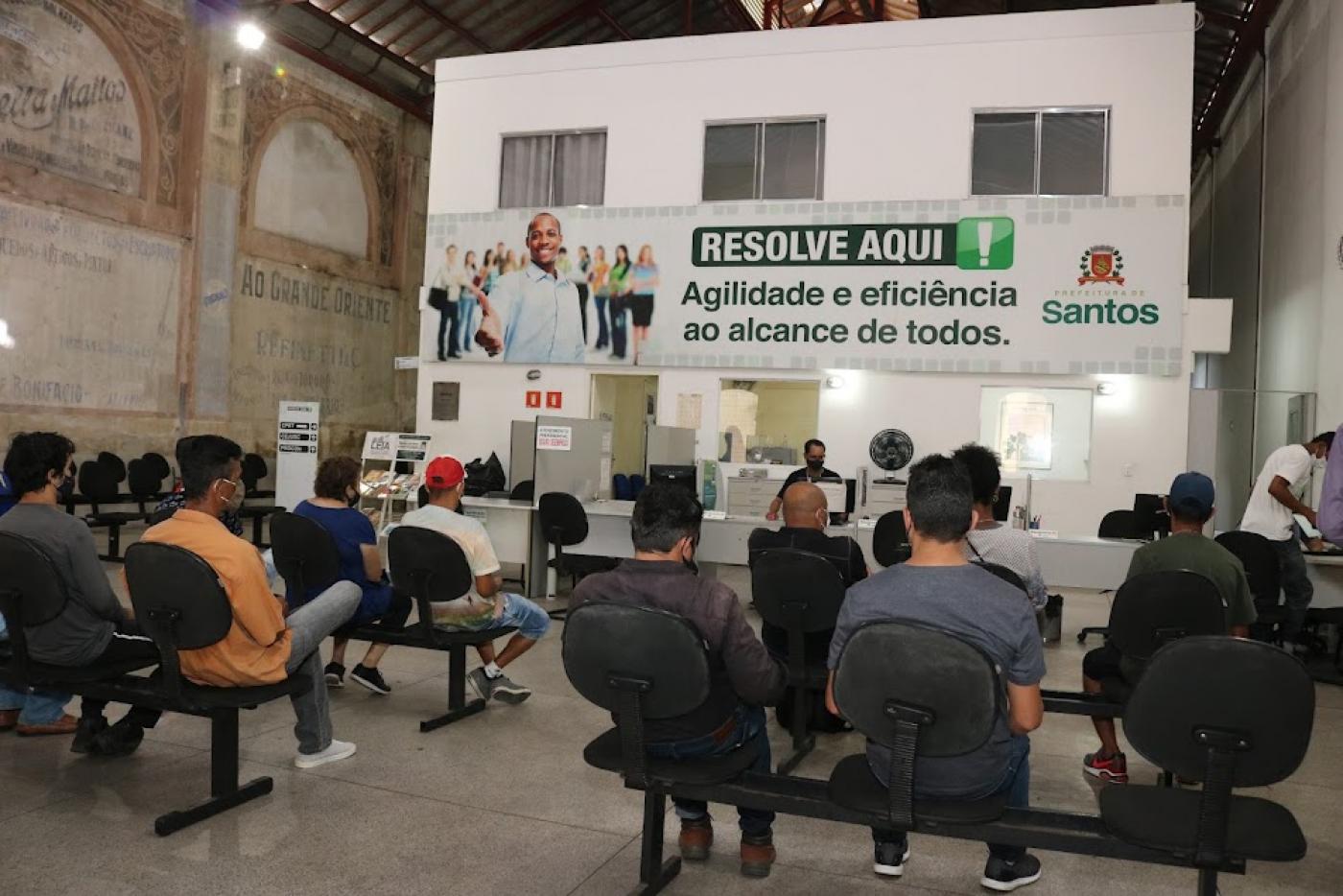 pessoas sentadas em cadeiras aguardando atendimento no centro de emprego. #paratodosverem