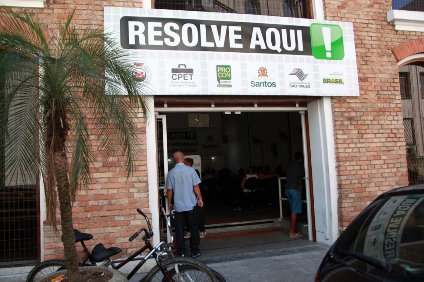 fachada do centro público de emprego. Na placa está escrito Resolve Aqui e aparecem os logotipos dos serviços internos. #Paratodosverem