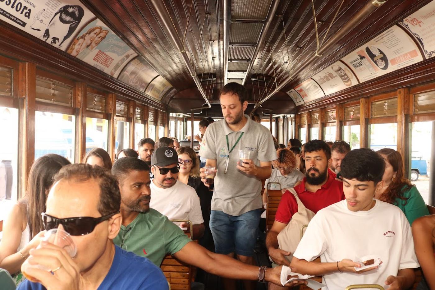 guia oferece cerveja a pessoas no bonde #paratodosverem