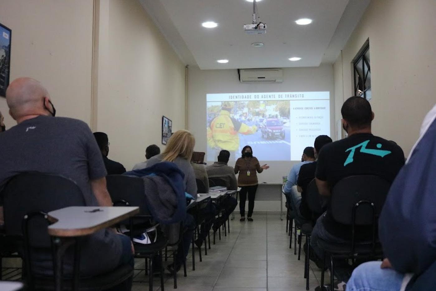 Mulher dá palestra para agentes. #paratodosverem