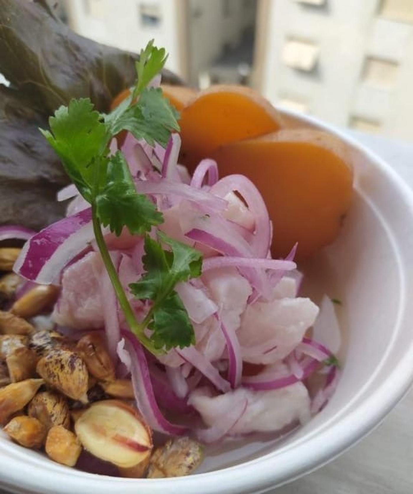 Prato de ceviche, com peixe, cebola, milho peruano e folhas de coentro. #Paratodosverem