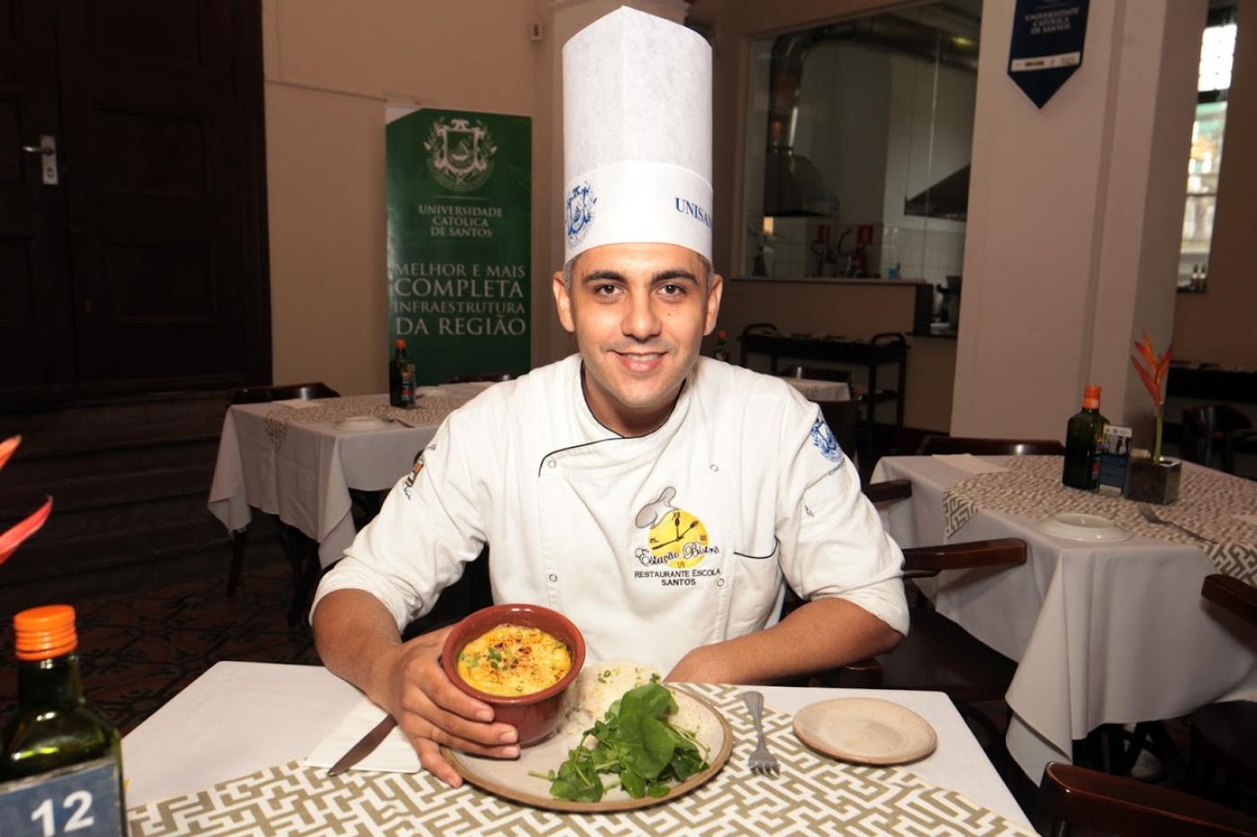 O chef Junior MOnteiro diante de um prato na mesa. #Paratodosverem