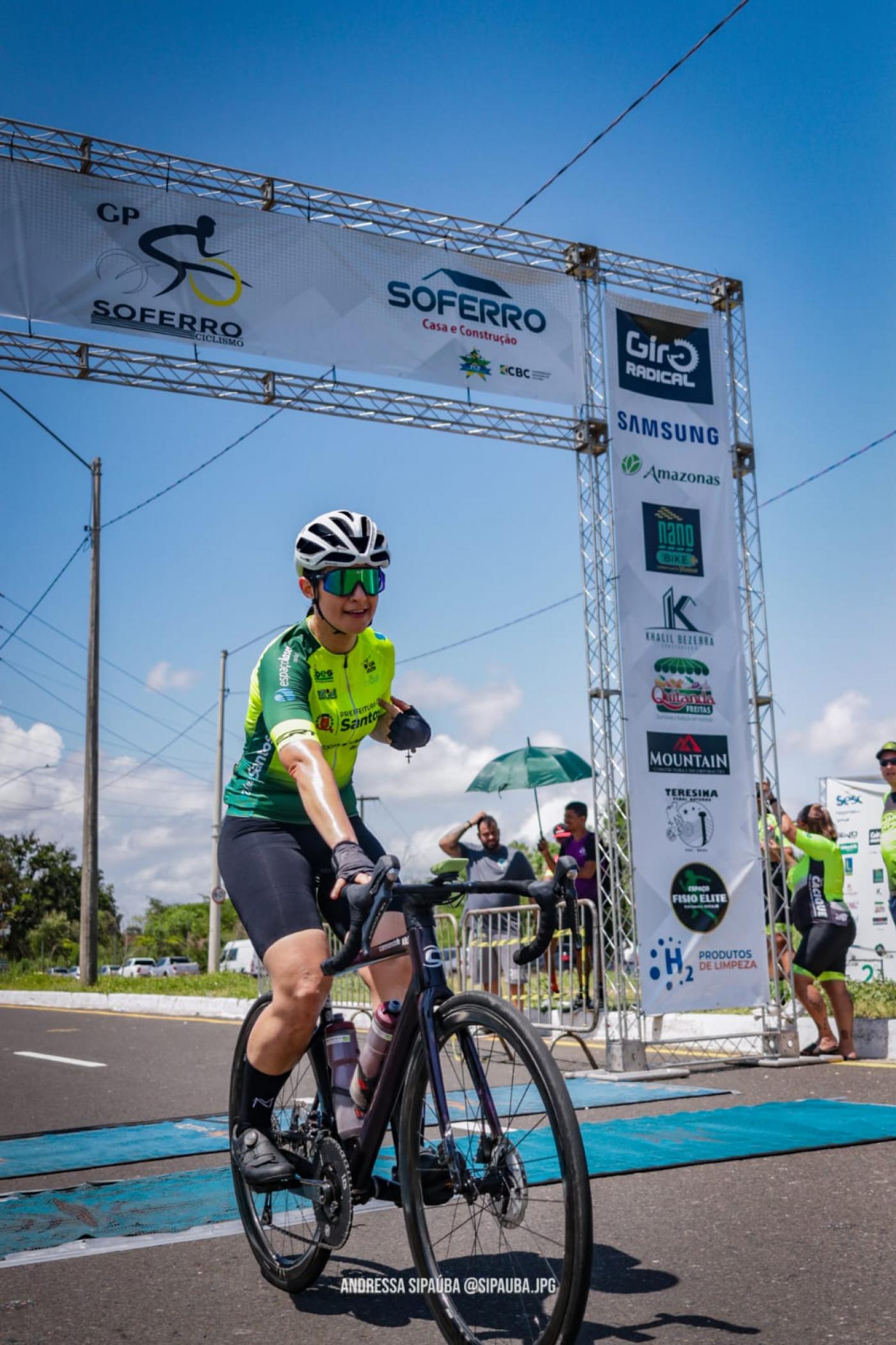 a atleta está cruzando a linha de chegada de bicicleta. #paratodosverem