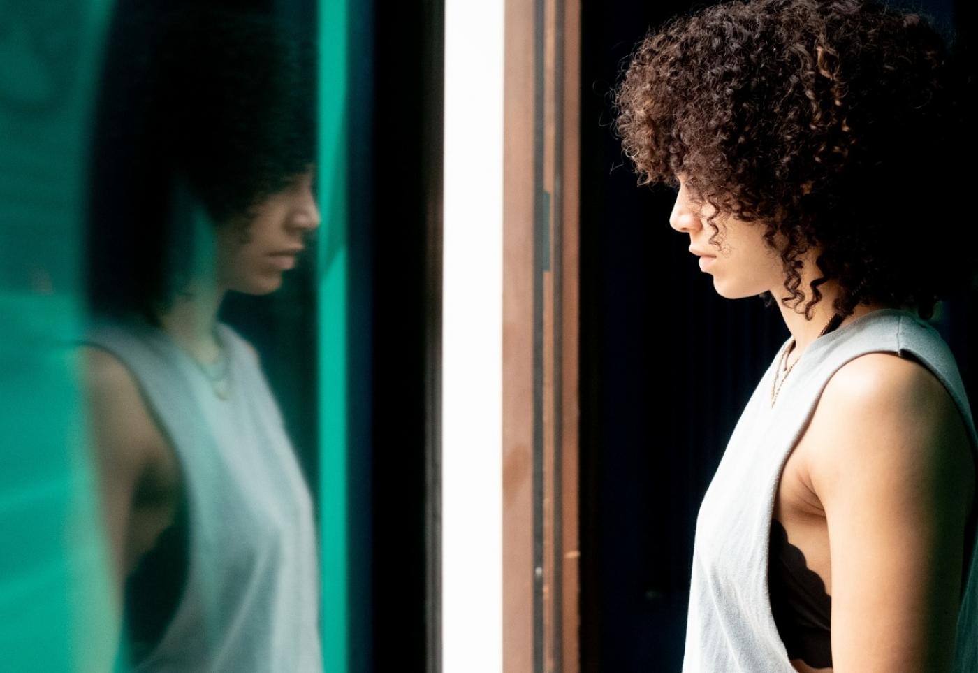 mulher negra se olha no espelho. #paratodosverem