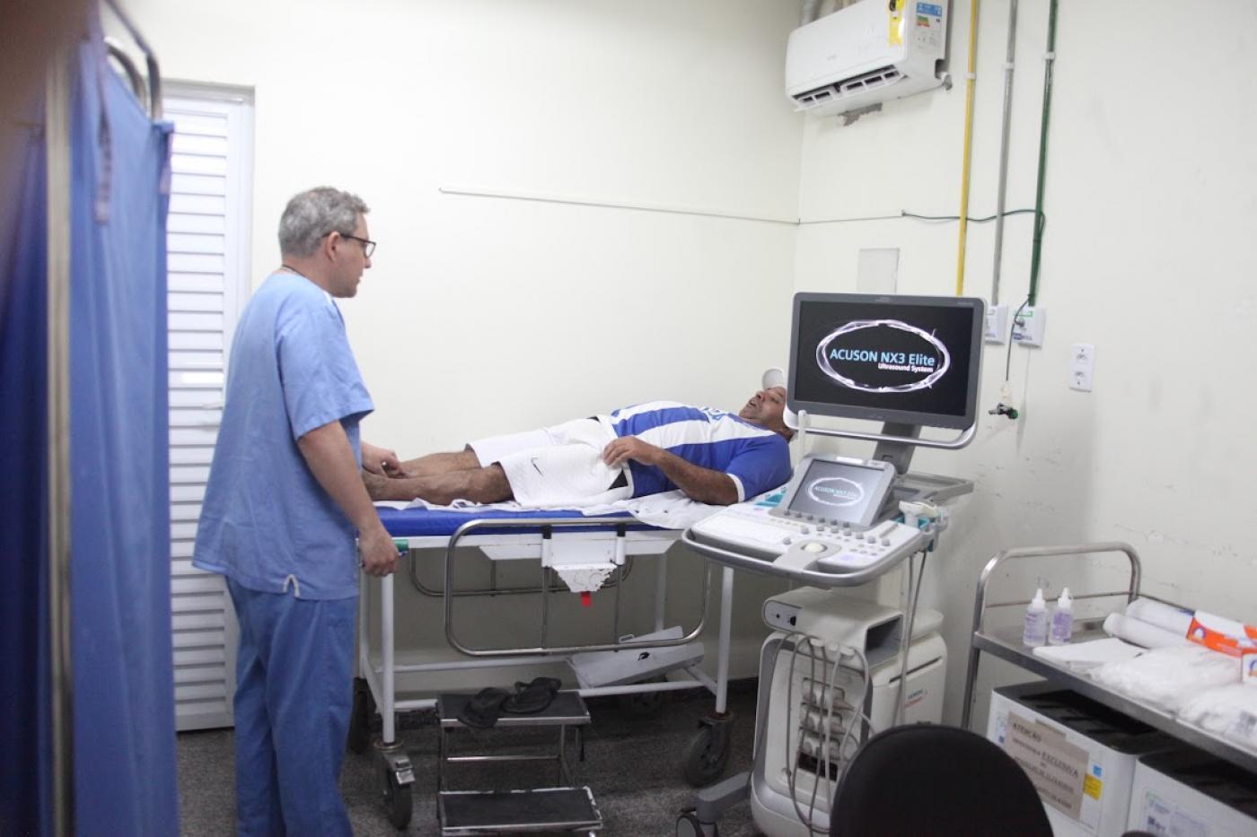 técnico faz exame em homem deitado #paratodosverem