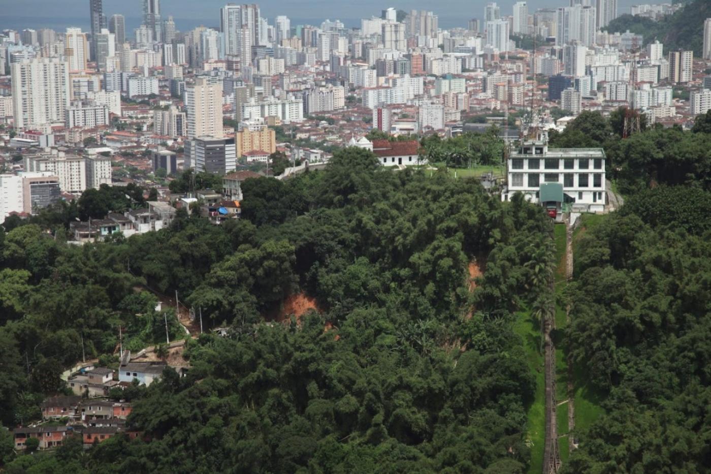 vista aérea de morro, com face verde e a cidade ao fundo. #partodosverem