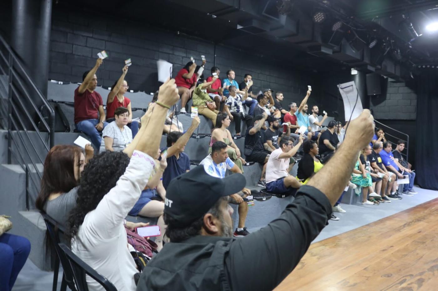 pessoas mostram papel na conferência #paratodosverem 