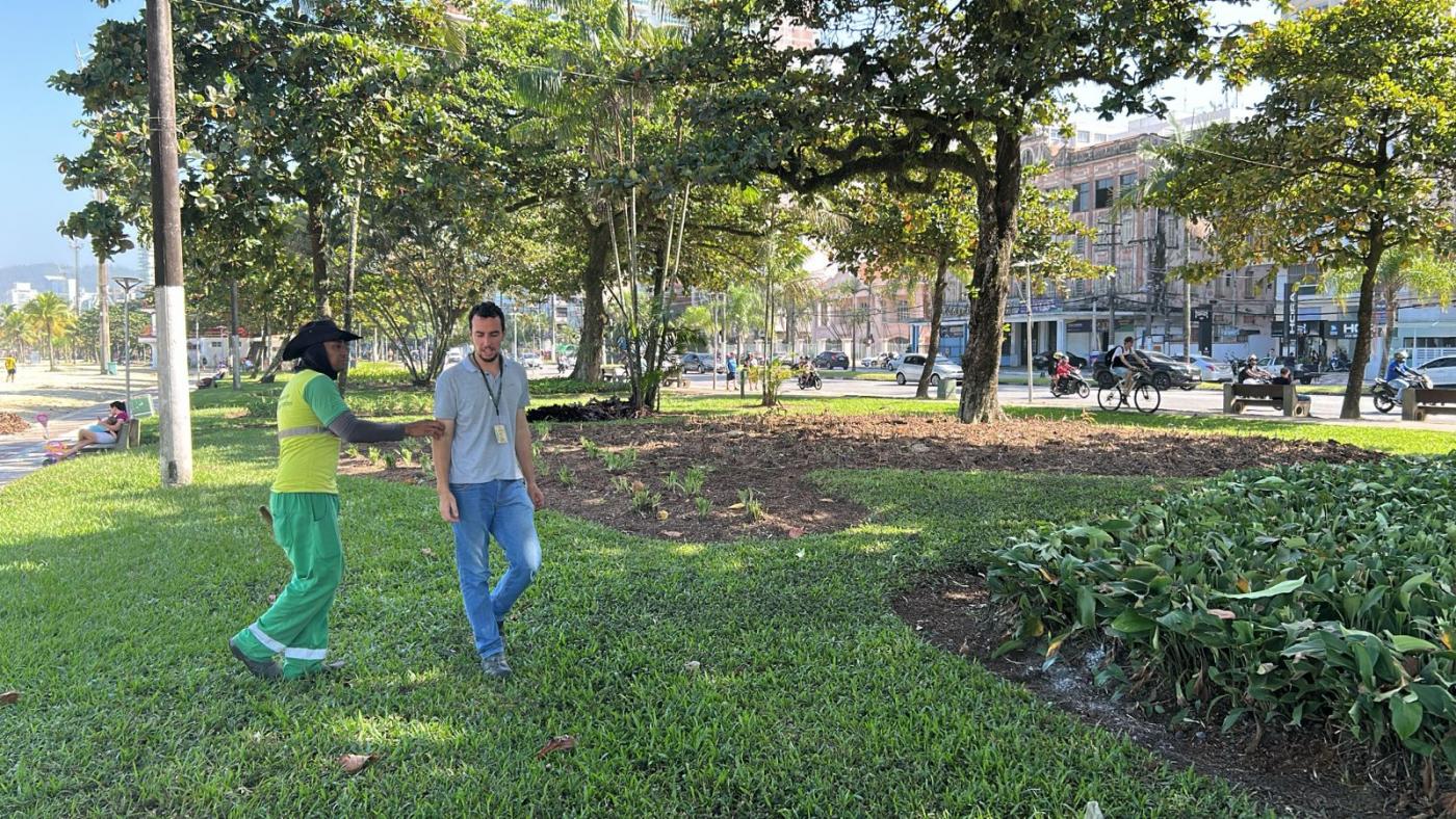 dois operários olham o jardim embelezado #paratodosverem 
