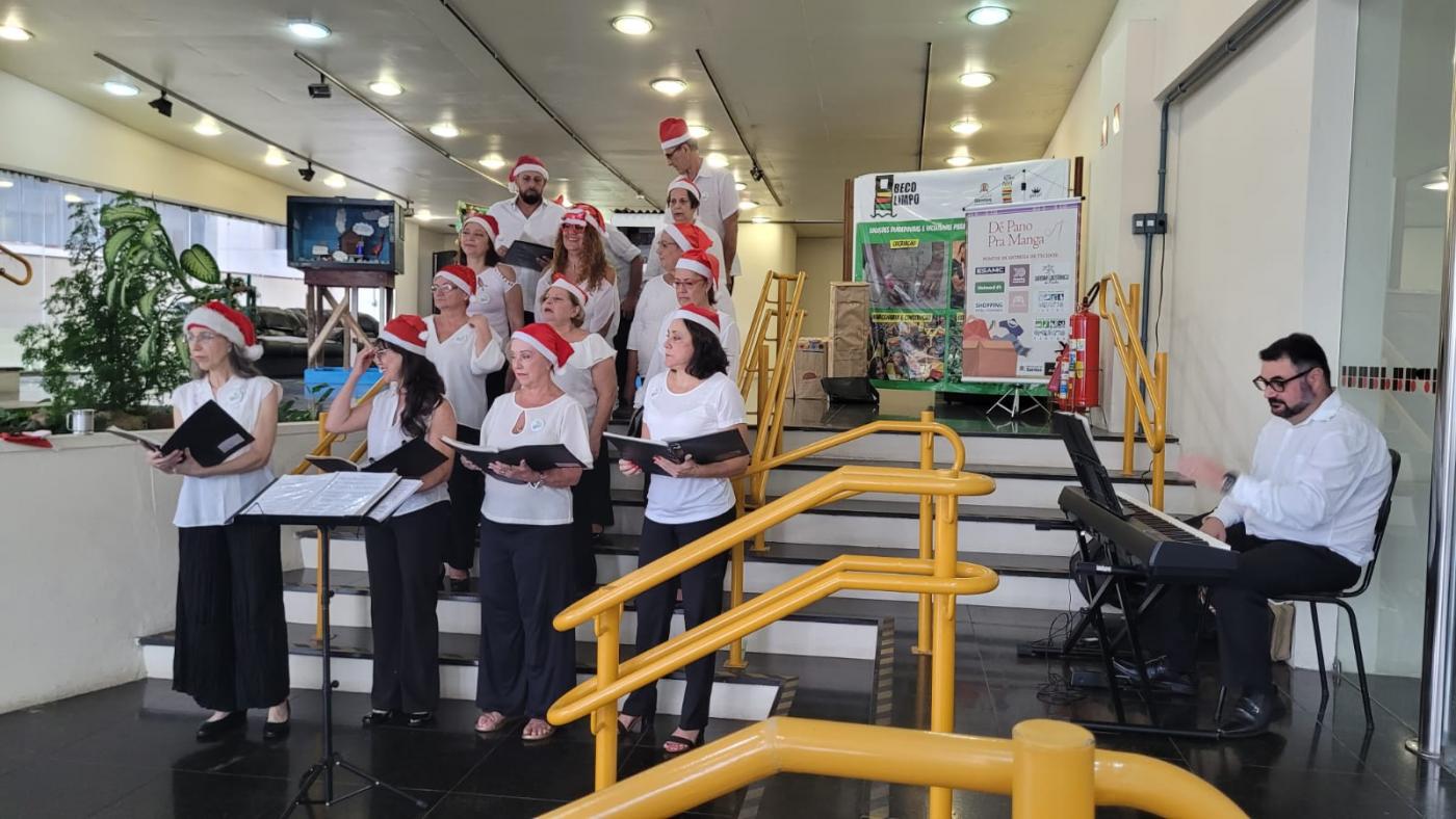 votsl dr sptrdrnyns à frente de uma escadaria em ambiente decorado de natal. #paratodosverem 
