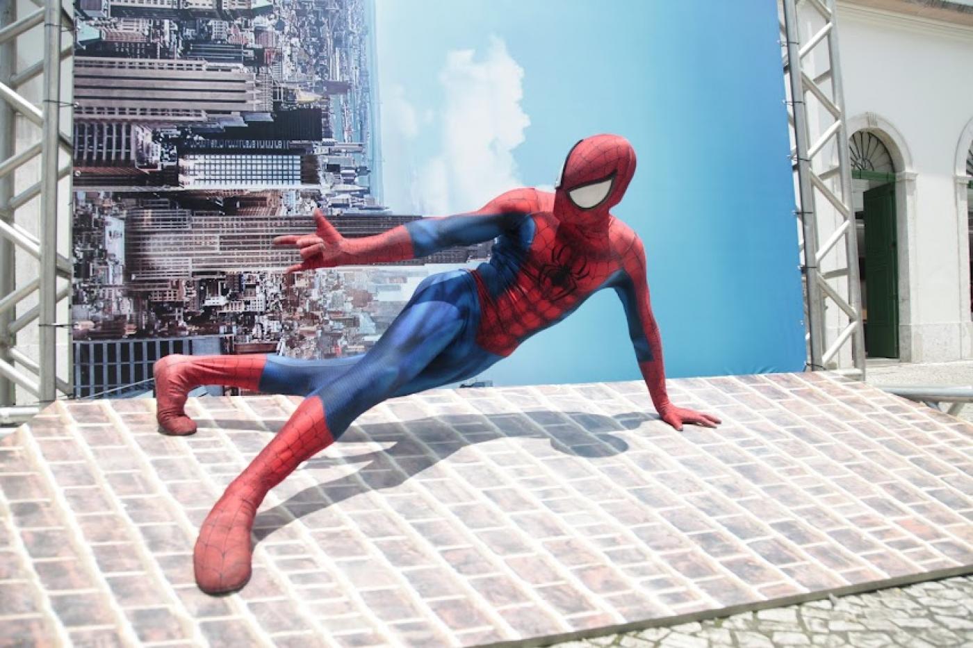 Homem aranha fantasiado faz movimento na calçada #paratodosverem