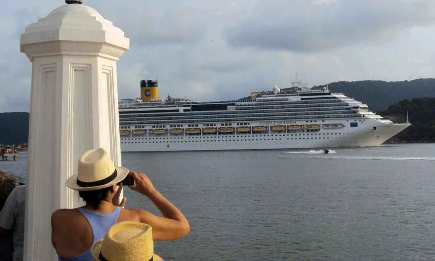 Mulher tira foto de cruzeiro no mar #paratodosverem