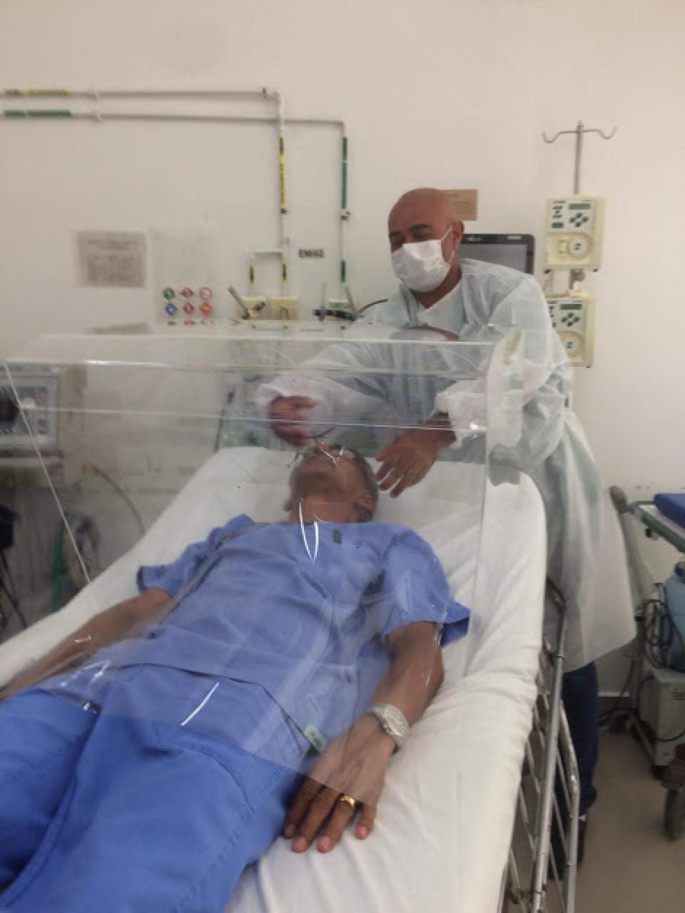 homem deitado em cama de hospital com o cubo plástico em volta #paratodosverem 