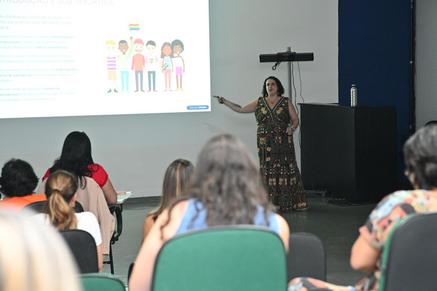 mulher fala para pessoas no auditório #paratodosverem