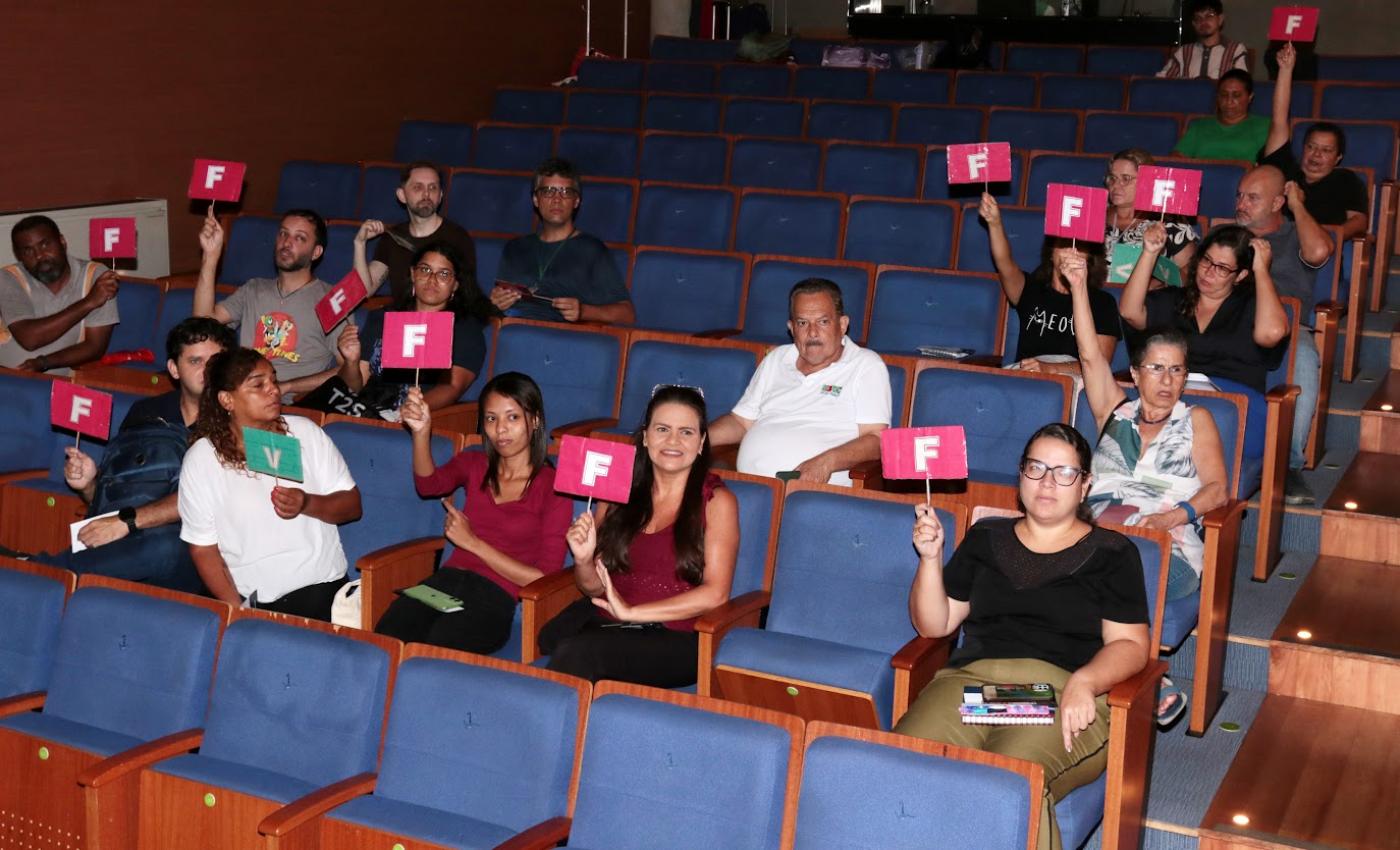 servidores seguram placas com v e f #paratodosverem