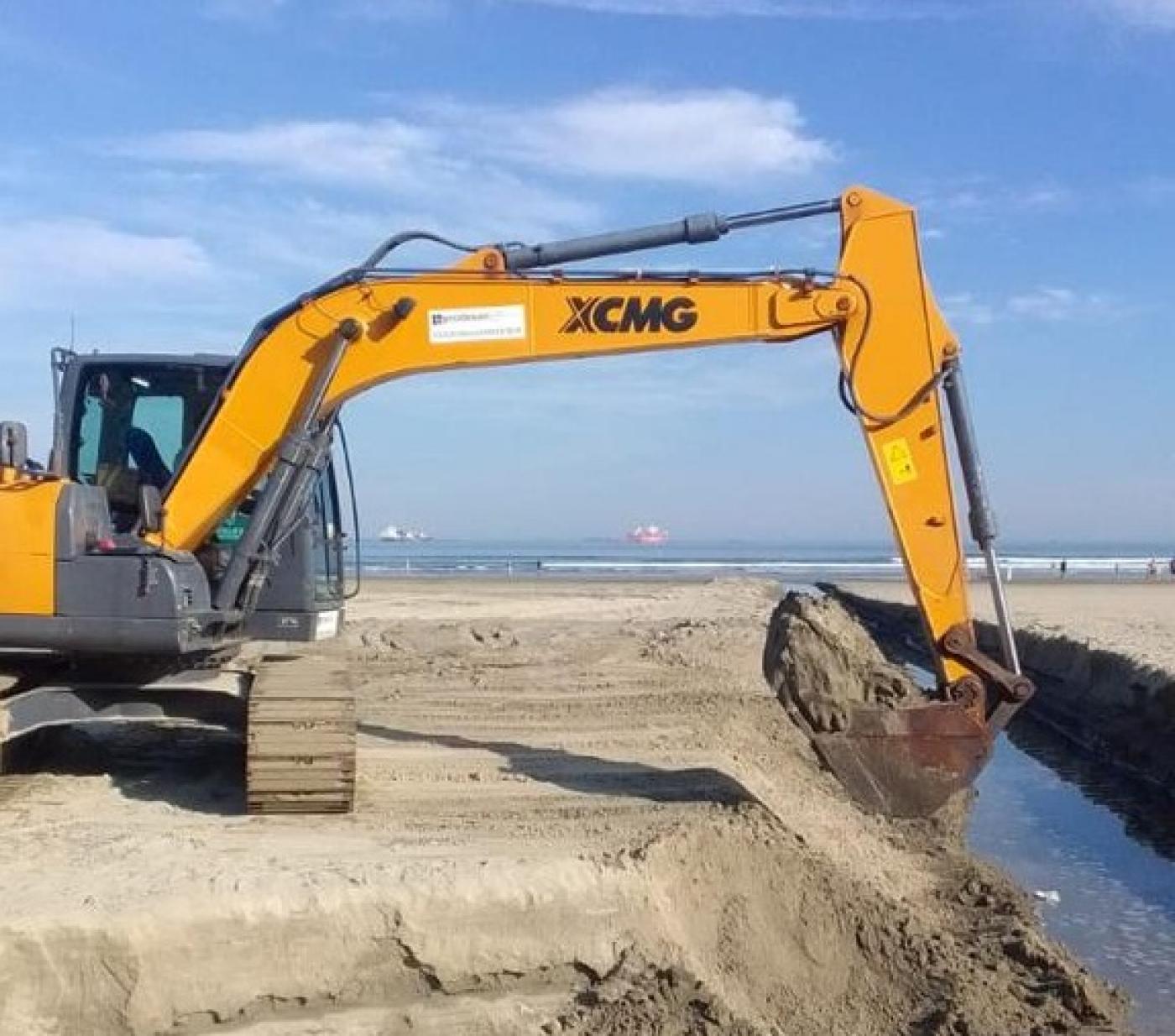 escavadeira remove volume de areia dentro de canal na faixa de areia da orla. #paratodosverem