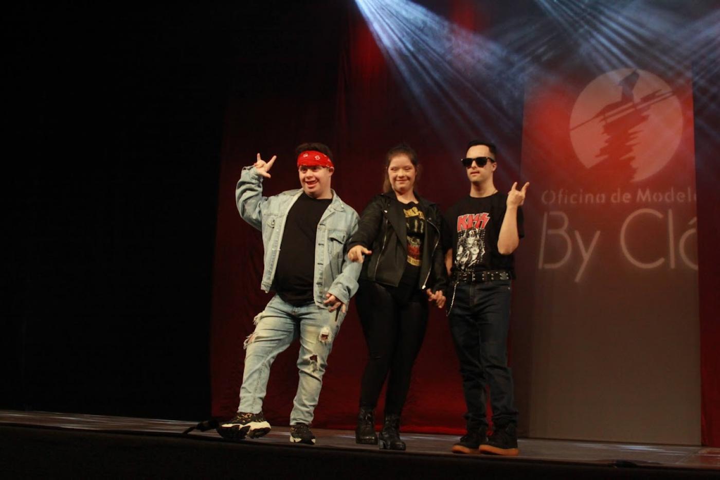 modelos portadores de sindrome de down no palco com roupa de rock #paratodosverem