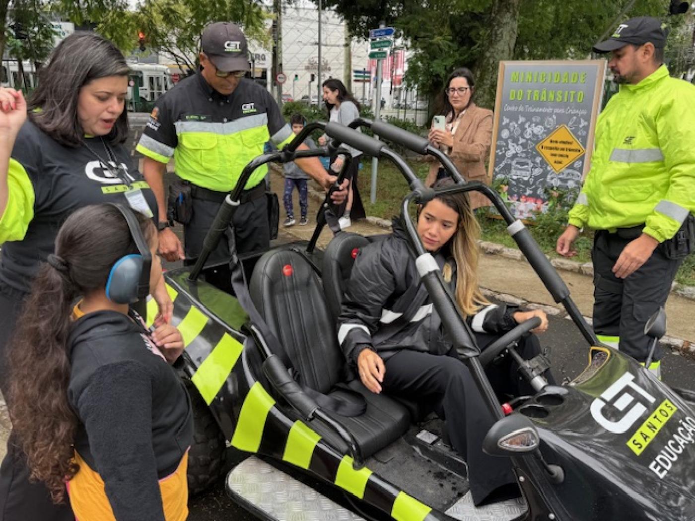crianças com abafadores de orelha estão dentro de mini buggy. #paratodosverem