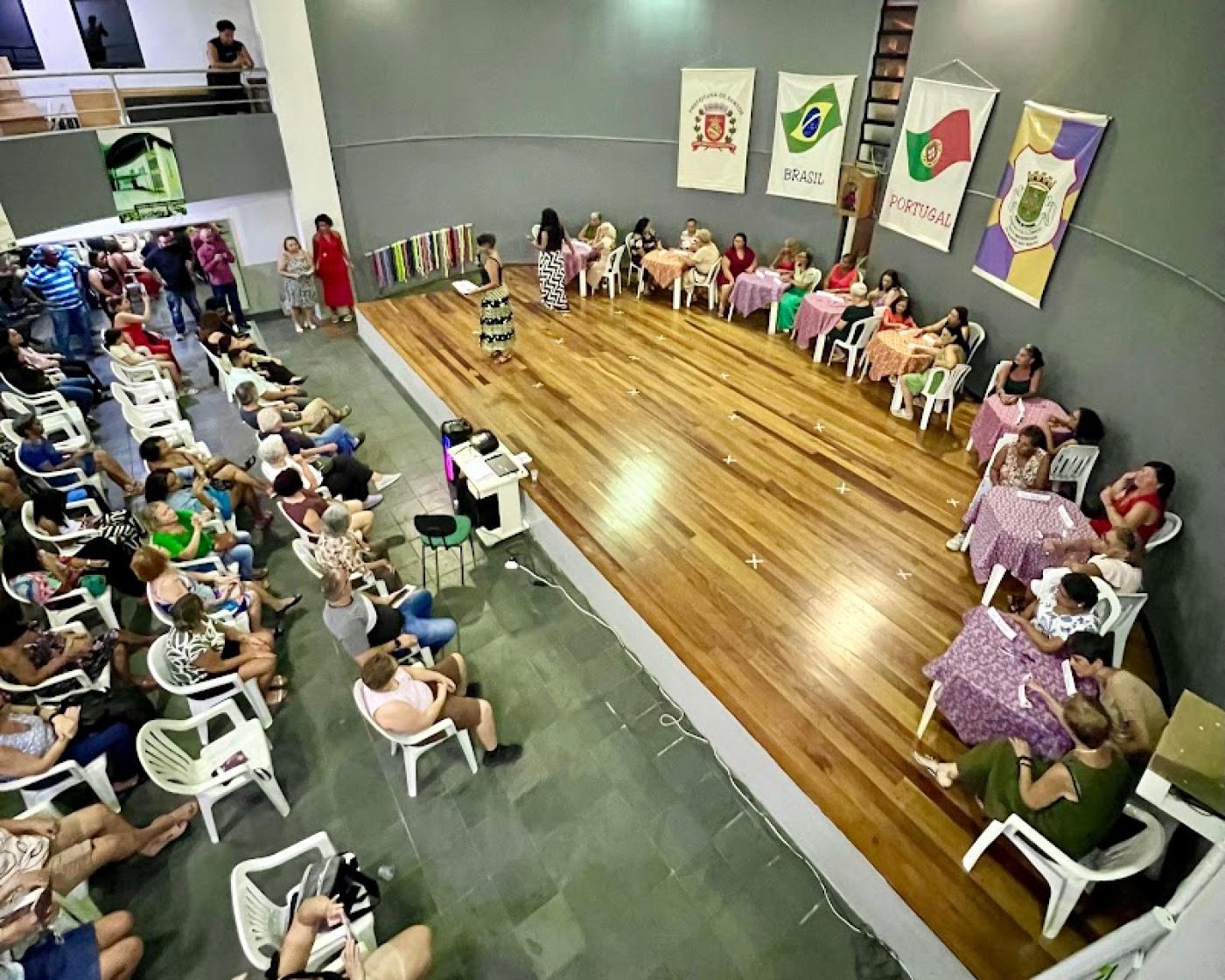 pessoas em um palco sentadas de frente para o público #paratodosverem