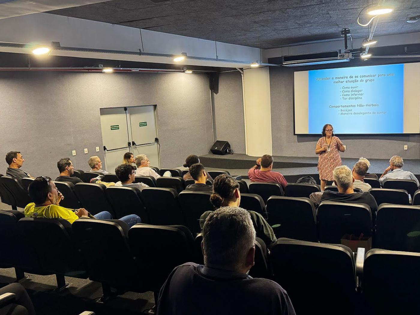 pessoas sentadas em auditório assistem palestra. #paratodosverem 