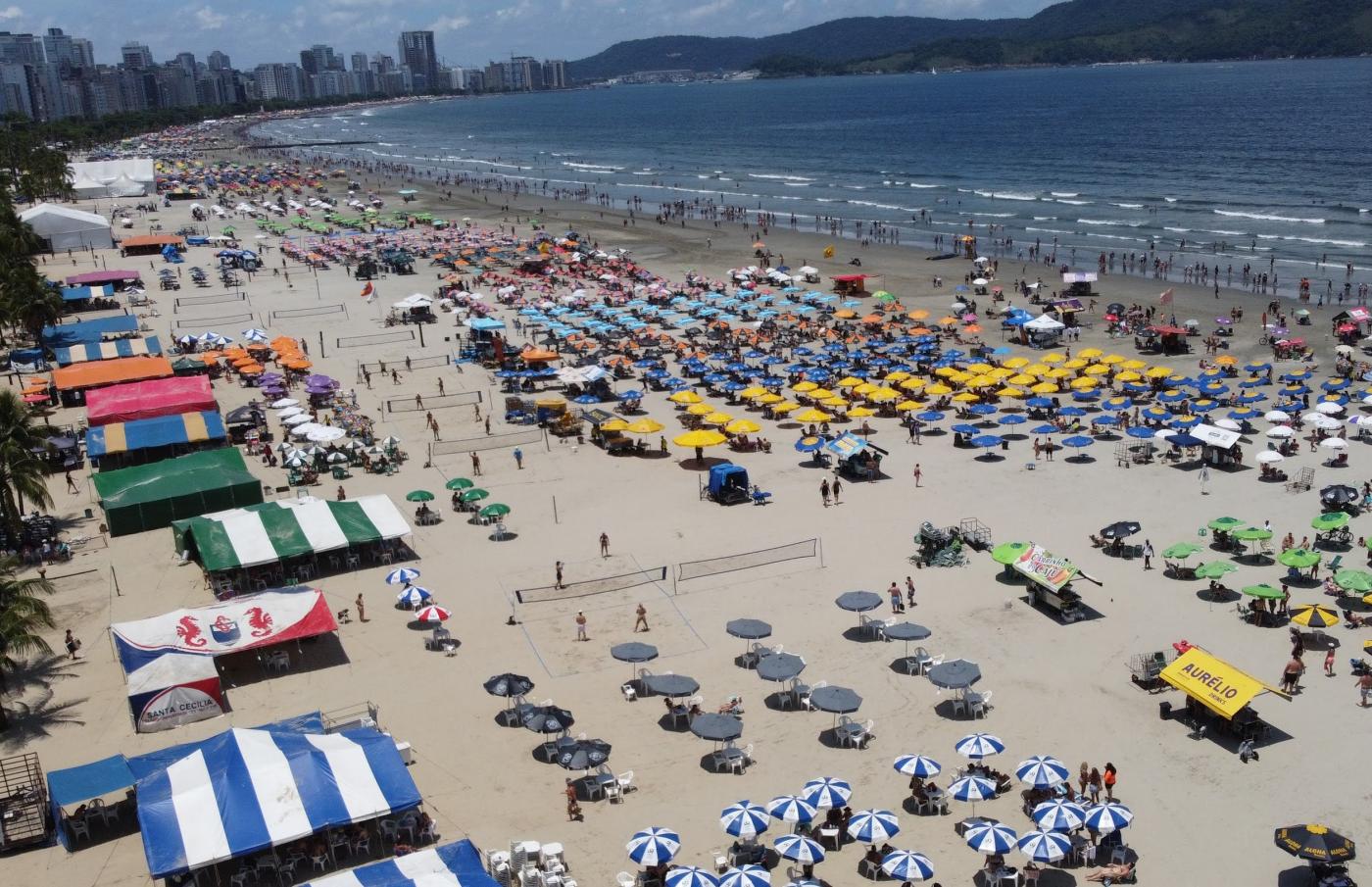 vista aérea da praia cheia em dia de sol. #paratodosverem 