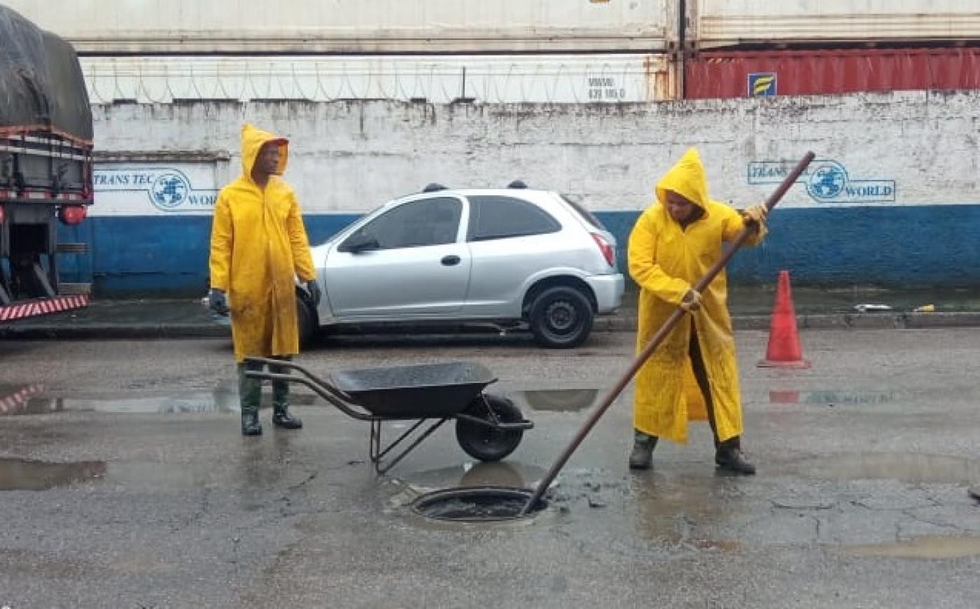 Profissionais realizam limpeza de caixa de passagem. #paratodosverem