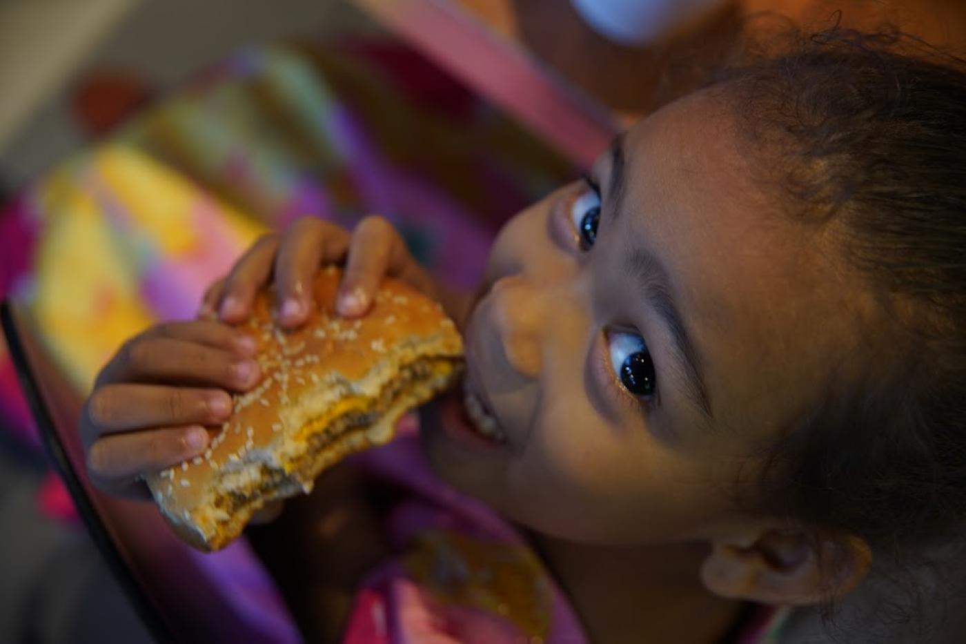 menina come sanduíche e sorri para a foto. #paratodosverem