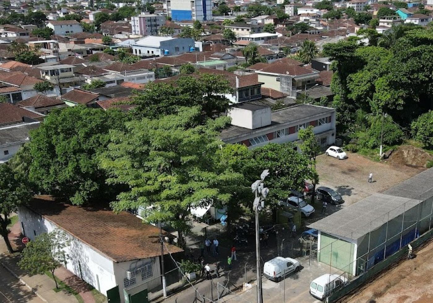 imagem área de terreno cercado por arvores e casas ao fundo #paratodosverem