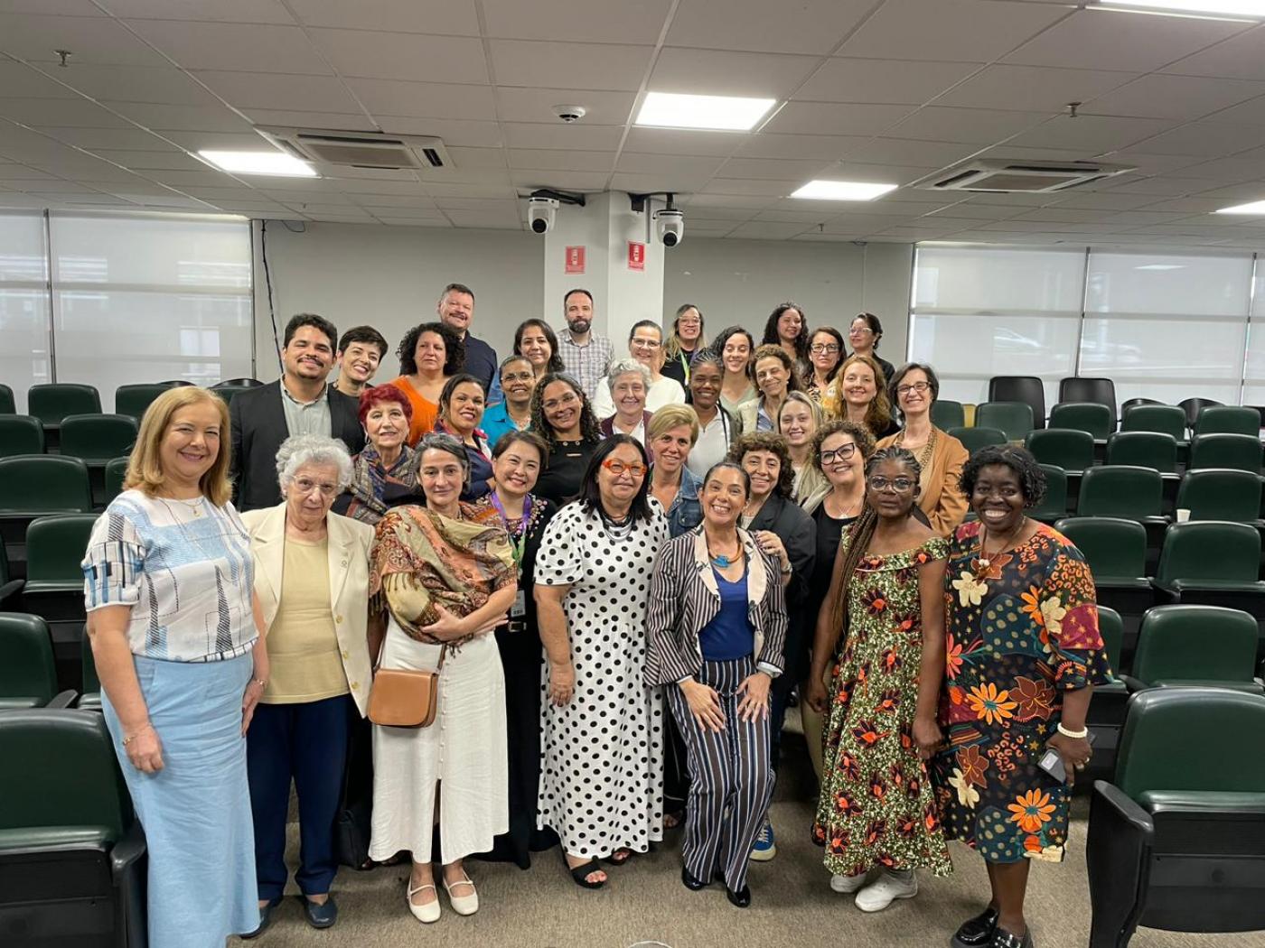 Pessoas posam para foto em auditório #paratodosverem