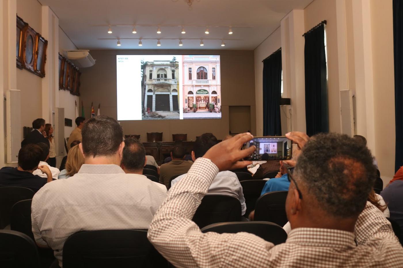 empresários na plateira tiram foto de apresentação #paratodosverem