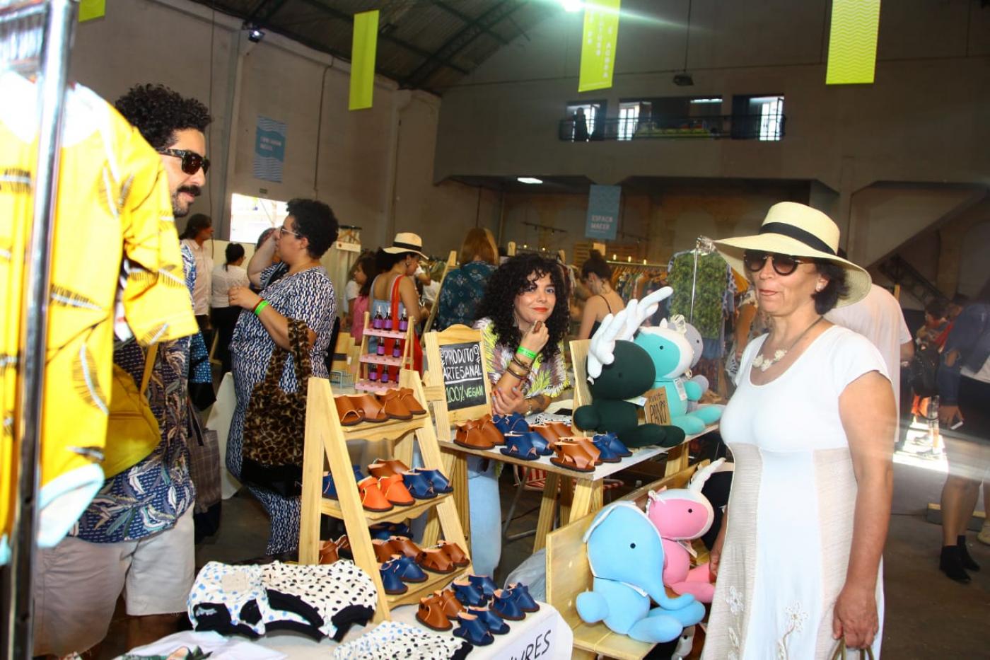 Mulher confere produtos artesanais em estande. #pracegover