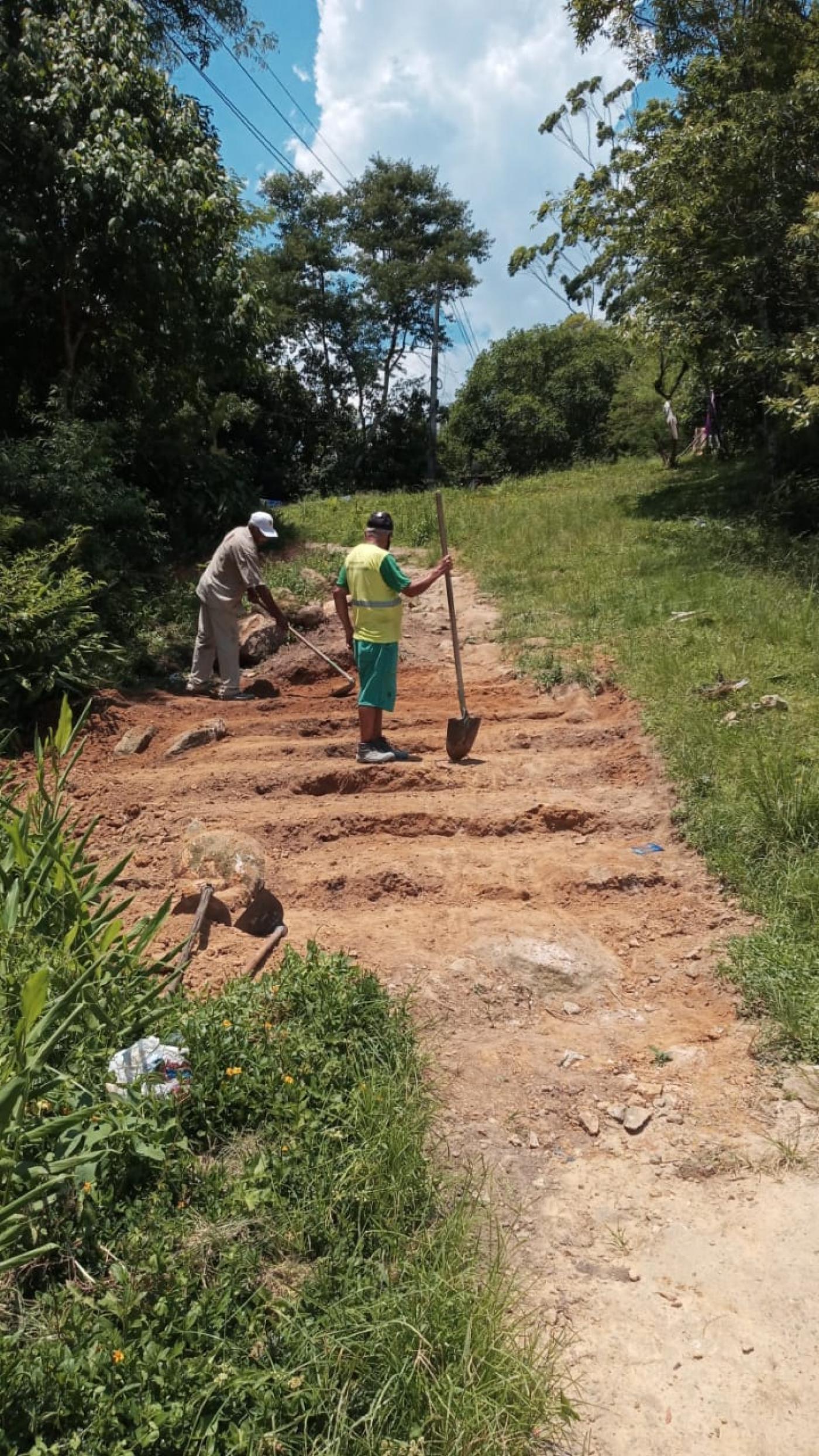 homens começam a fazer degraus de escada em área com vegetação. #paratodosverem