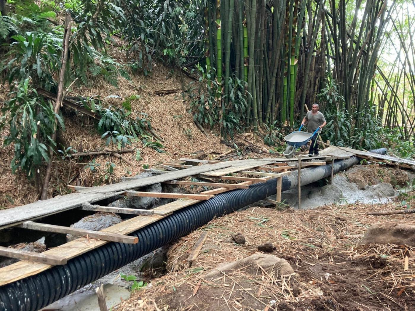 Trecho de encosta com construção de desvio de tubulação. #paratodosverem