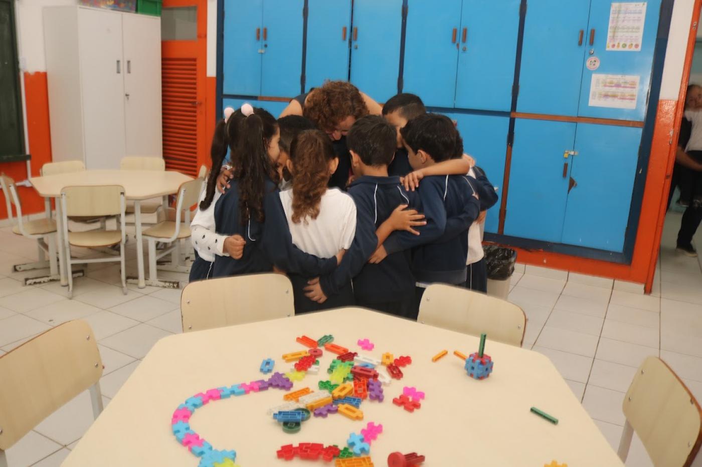 crianças abraçam professora #paratodosverem